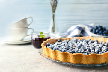 Plate with delicious blueberry pie on table
