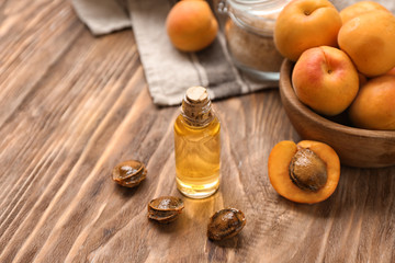 Bottle of apricot essential oil on wooden table