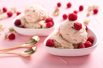 Bowl with tasty ice-cream and raspberries on color background