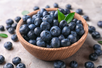 Bowl with ripe blueberries on light table