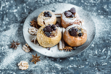 Fruit dessert baked  apples stuffed with blackberry, blueberries, cinnamon, nuts, honey. Autumn or winter dessert. Top view