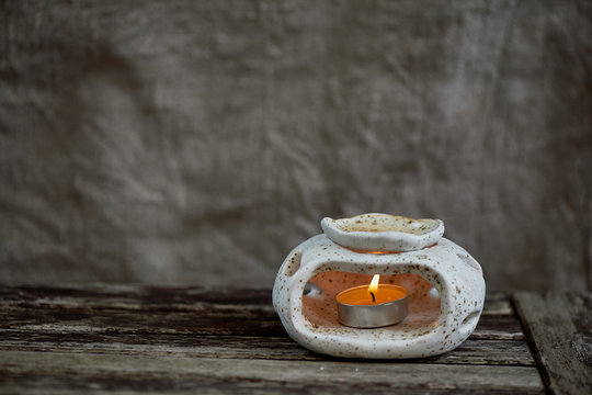 Handmade ceramics. Scented lamp with burning candles. The woman's hand is pouring water. Relaxation and meditation