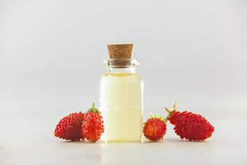 Essence of Wild strawberry on White background in beautiful glass jar