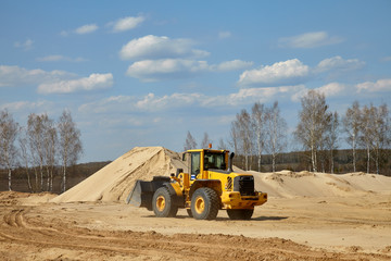 Front end loader scoops up a sand near an aerated concrete plant