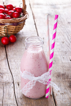 smoothie with red and black currant in vintage bottle,old wooden board