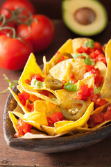nachos loaded with salsa, cheese and jalapeno