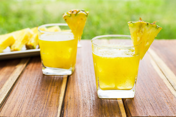 Pineapple fruits drink on wooden background.