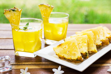 Pineapple fruits drink on wooden background.
