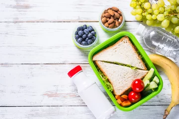Foto op Canvas Lunchbox met sandwich, groenten, yoghurt, noten en bessen. © nadianb