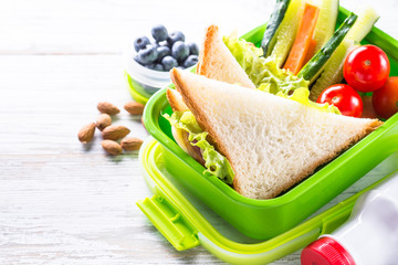 Lunch box with sandwich, vegetables, banana, water, nuts and ber