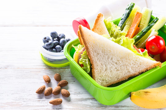 Lunch box with sandwich, vegetables, banana, water, nuts and ber