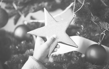 Little kid holding a Christmas tree star ornament