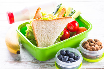Lunch box with sandwich, vegetables, banana, water, nuts and ber © nadianb