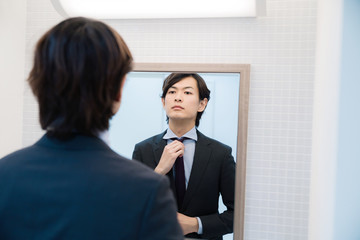 鏡を見る男性 © metamorworks