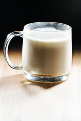 Glass of fresh milk is wooden table on kitchen desk background