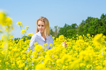 Naklejka na ściany i meble Woman in a meadow in yellow flowers