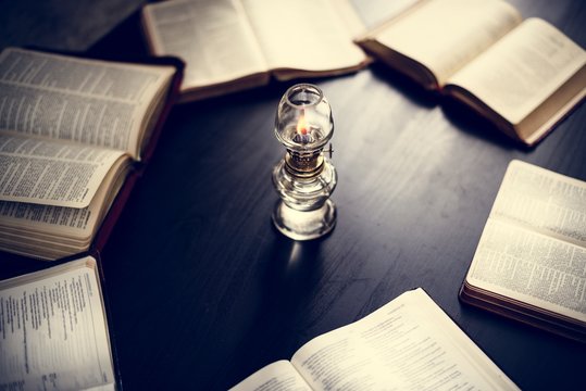Closeup of holy bibles on the wooden table with candlelit