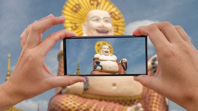 Cinemagraph of Taking Mobile Photo of Chinese Laughing Buddha at Plai Laem Temple - Main Symbol and Popular Landmark of Samui Island in Thailand. Tourism and Sightseeing