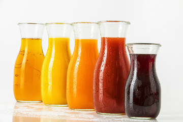 unterschiedliche Fruchtsäfte in Glasflaschen vor weissem Hintergrund, Freisteller