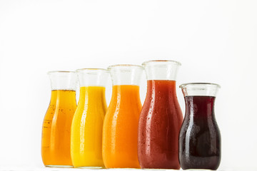 Fototapeta na wymiar unterschiedliche Fruchtsäfte in Glasflaschen vor weissem Hintergrund, Freisteller
