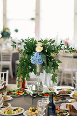 Banquet table is decorated with compositions of hydrangea flowers and greenery