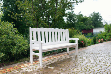 Lounge area for guests outside. Wedding decor. White bench in the park