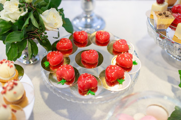 Red cupcakes ina shape of heart on banquet table. Wedding table setting