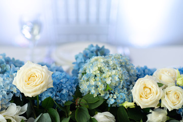 Banquet table is decorated with compositions of hydrangea flowers and greenery