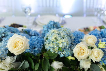 Banquet table is decorated with compositions of hydrangea flowers and greenery