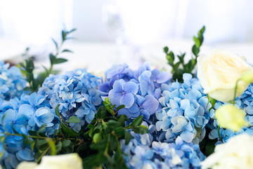 Banquet table is decorated with compositions of hydrangea flowers and greenery