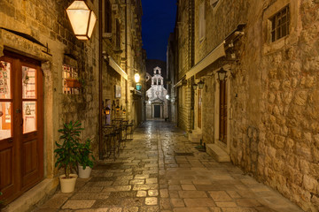 Dubrovnik, night view of the Church of St. Dominic of their alley, lit by street lamps. Croatia.