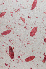 Handmade paper texture with recycled materials, tree leaves and cotton fibers. In delicate tones, reds, garnets and vanilla