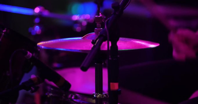 Cymbals on a drum set close up being played by drummer on stage