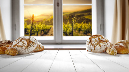 Fresh bread on white wooden table and window background. Free space for your decoration. 