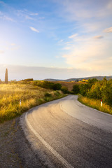 beautiful winding country road leading through rural countryside in the Italy Tuscany District with...