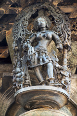 Shilabalika, celestial maiden, in a beauty dance pose. A lady practicing dance steps. Her maids are playing their musical instruments . Chennakeshava temple, Belur, Karnataka. Notice the hairstyle.
