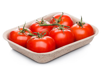 Tray with fresh raw organic tomatoes on white