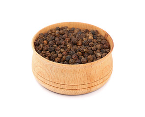 Wooden bowl full of black peppercorns