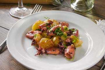 Alluring dish made of grilled squid and baked potatoes. Close up.