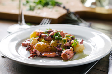 Alluring dish made of grilled squid and baked potatoes. Close up.
