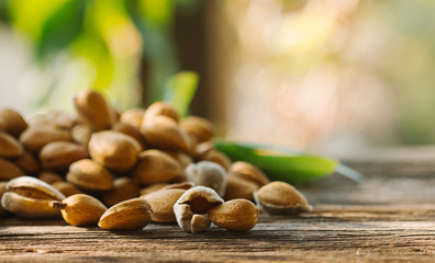 Pile of fresh raw almonds on a rustic wooden table.