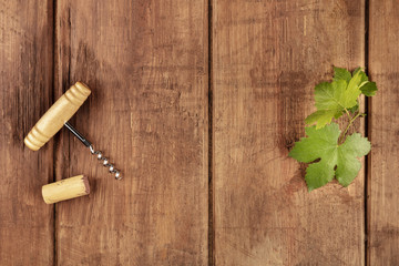Overhead photo of vine leaf with corkscrew, cork, and copyspace