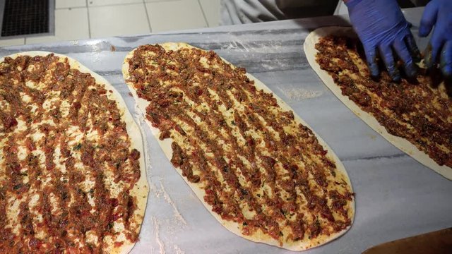 Chef makes pide with meat.