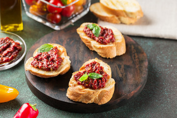Bruschetta with tomato sauce and basil. Fresh baguette, tomatoes on wooden serving board.