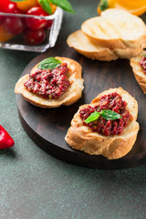Bruschetta with tomato sauce and basil. Fresh baguette, tomatoes on wooden serving board.