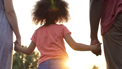 Little girl holds fathers and mothers hands, happiness and wellbeing in family © motortion