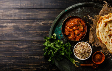 Chicken tikka masala spicy curry meat food with rice and naan bread on dark background copy space