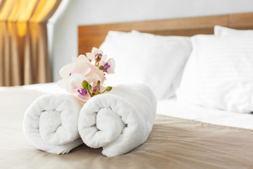 Naklejka na ściany i meble towels and flower on bed in hotel room