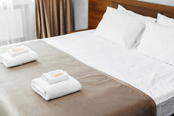 Fototapeta na wymiar White towel on bed in guest room for hotel customer