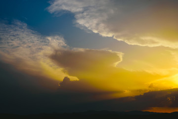 Beautiful sunset with the sun of orange tones behind the mountains and deep blue sky